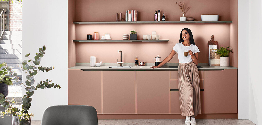 Grifflose LINE N Küche in Koralle mit eleganter Griffmulde – modernes, reduziertes Design für offene Wohnräume.